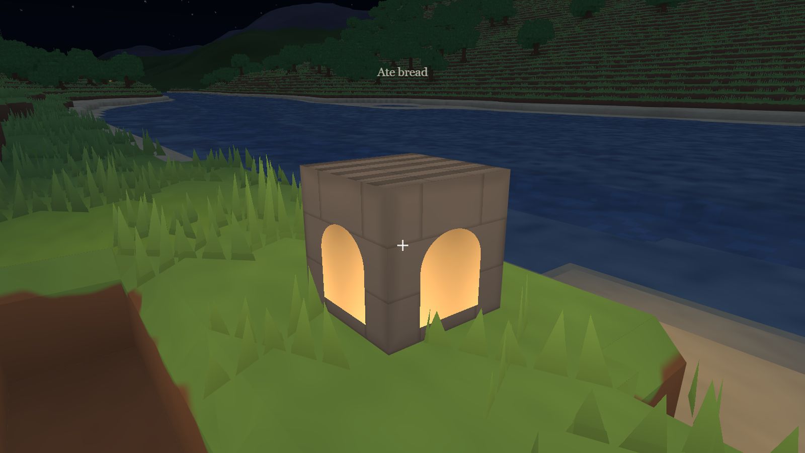 A stone furnace glowing by the river at dusk